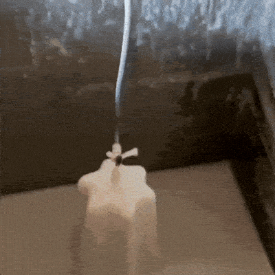 Vela siendo bañada en parafina de color blanco, para su posterior proceso de tallado a mano.